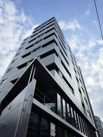 コンクリート打ち放し。1階・2階の事務所部分が一面ガラス張りで洗練された印象。
