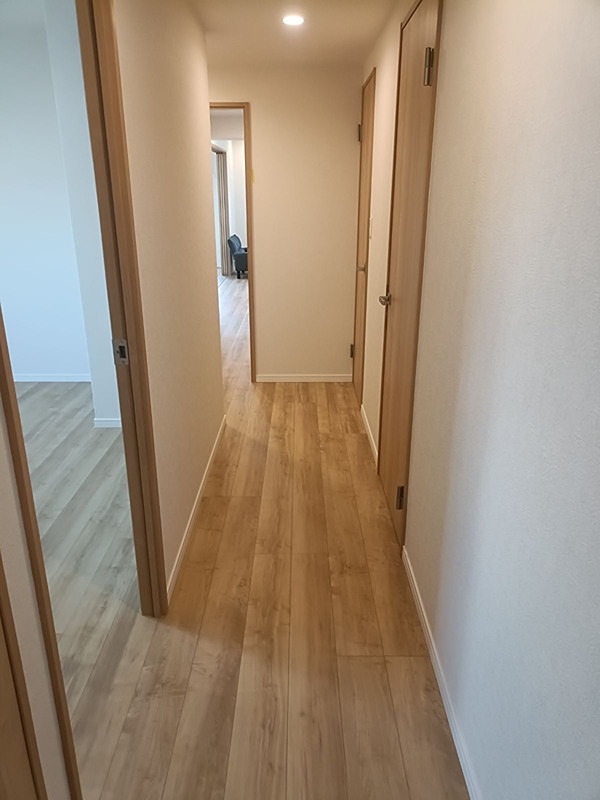 明るい木目調のフローリングが特徴の廊下です。各部屋へ繋がる扉も同系色で統一され、すっきりとした印象を与えます。 日興千里丘スカイマンションB棟 501号室 その他