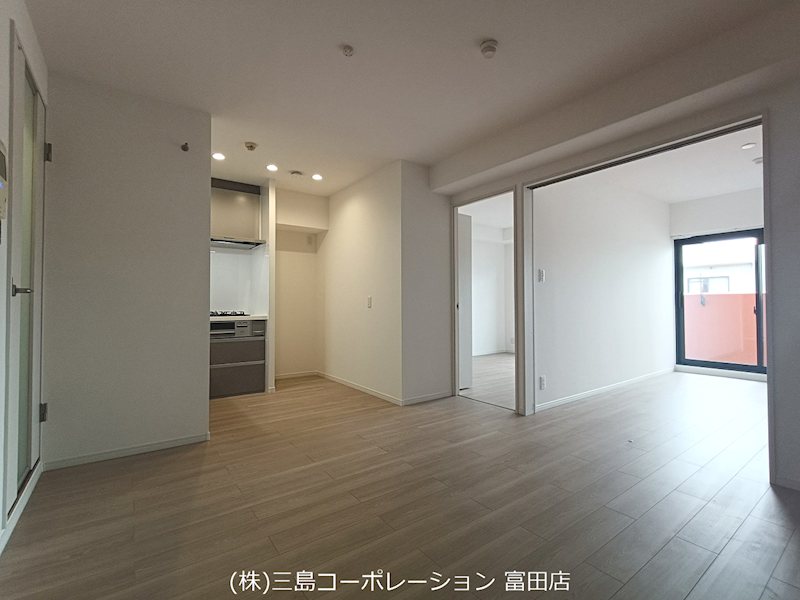 明るい木目調の床と白い壁が広がるリビング。隣接する洋室の扉を開けば、開放的な空間が生まれます。 ライオンズマンション高槻 その他