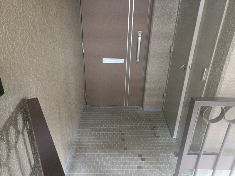 落ち着いた色合いの玄関扉が、お客様をお迎えします。足元のタイルは表情豊かで、日々の出入りに彩りを添えます。 日興千里丘スカイマンションA棟 203号室 その他