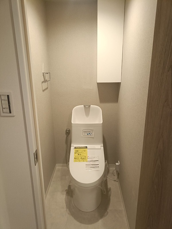 清潔感あふれるトイレは、日々の生活を快適に過ごすための大切な空間です。収納も完備されており、ストック品の整理整頓にも配慮しています。 日興千里丘スカイマンションA棟 203号室 その他